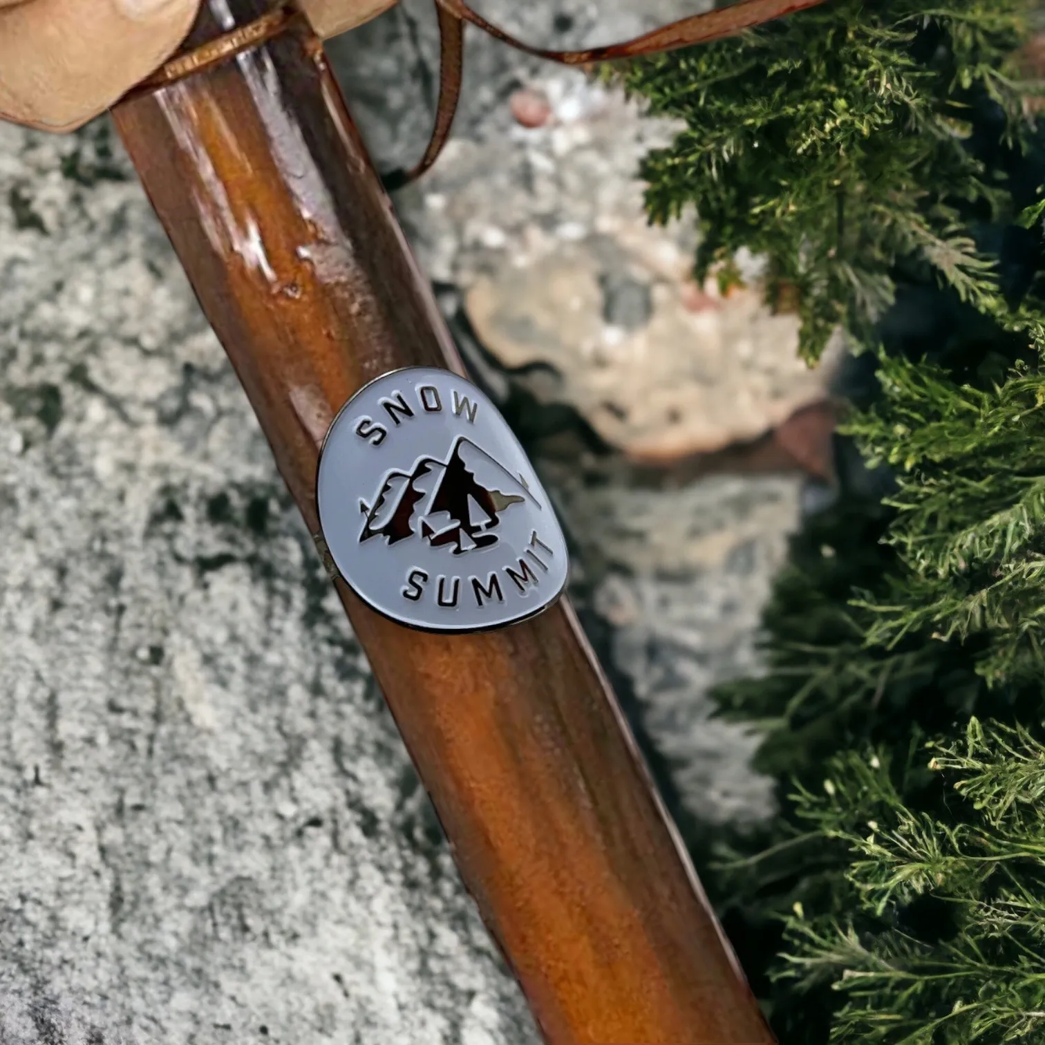 Metal medallion with two screws and a snow summit logo on it